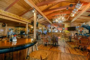Rustic interior of the Bull Moose Saloon & Lodge featuring wooden decor, a bar with seating, and a cozy dining area, highlighting the casual Western atmosphere for dining and socializing.